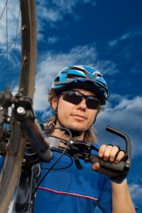 portrait of a young bicyclist in helmet with bicycle